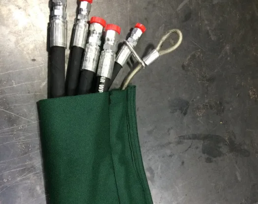 Green sleeve over hydraulic hoses