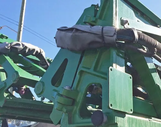 Grey sleeve on implement hoses