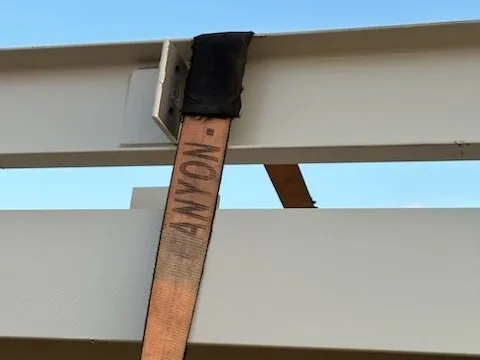 Strap saver where a strap crosses a beam