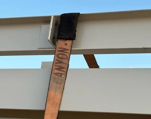 Strap saver where a strap crosses a beam