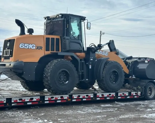 Covered wheel loader on a trailer