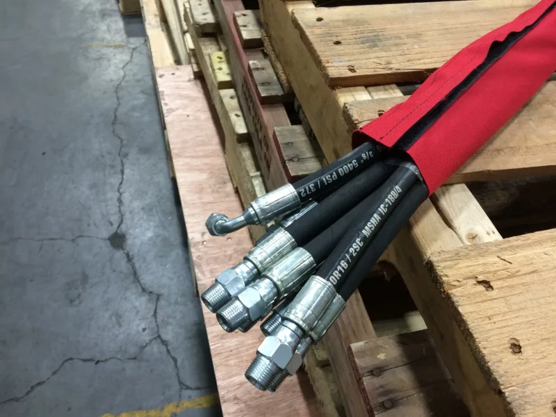 Red sleeve bundling hydraulic hoses