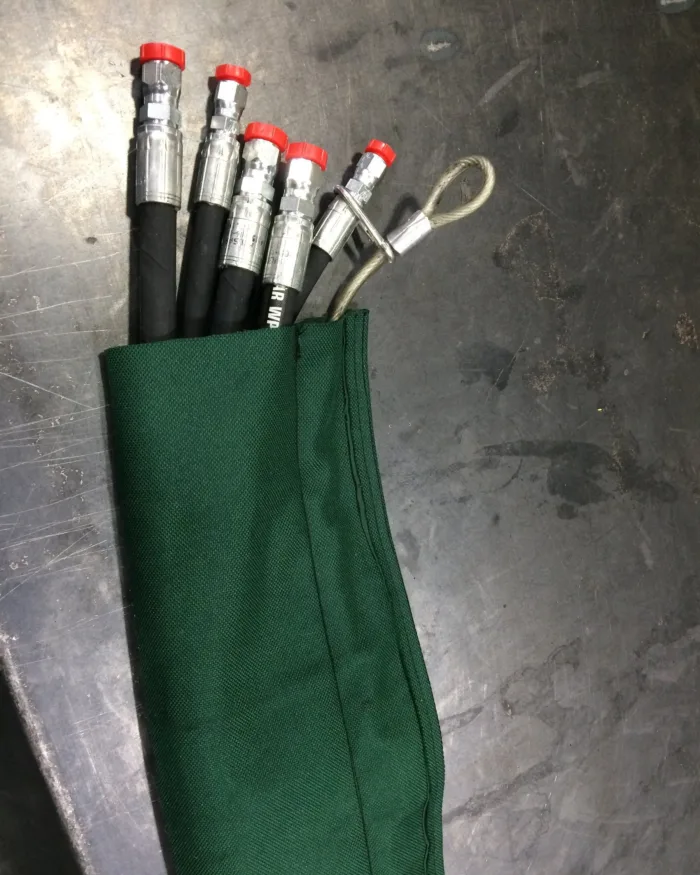 Green sleeve over hydraulic hoses