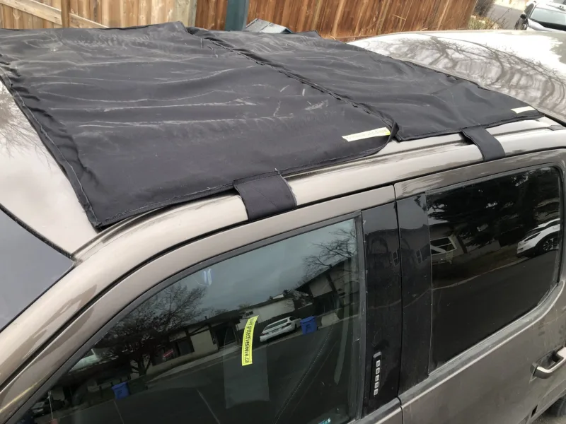 Hail cover strapped to a pickup roof